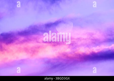 A Full Moon Against A Detailed Colorful Cloudscape Stock Photo
