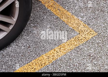 close up of a car wheel and parking lines painted on asphalt Stock Photo