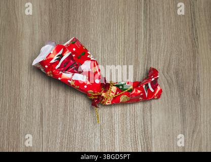 Christmas wrapping paper tied with ribbon on wooden floor Stock Photo