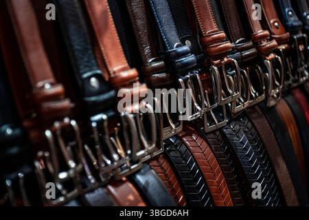 Florence, Italy 1 January 2025: Various leather belts with buckles are displayed in a craftsman's workshop in florence, italy, showcasing traditional Stock Photo