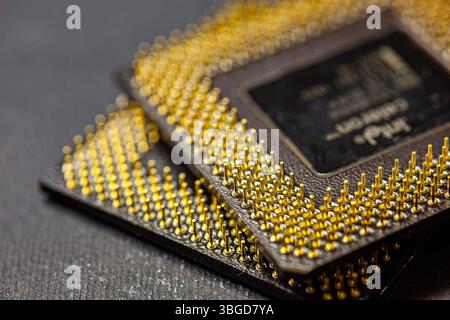 Milan, Italy 1 January 2025: Close-up of two computer processors with golden pins lying on a dark surface, showcasing their intricate details Stock Photo