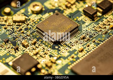 Milan, Italy 1 January 2025: An infineon technologies microcontroller takes center stage on a densely populated printed circuit board, highlighting th Stock Photo