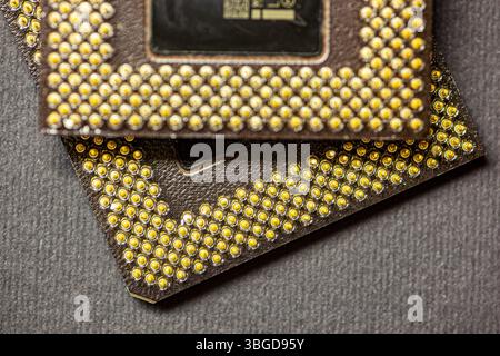 Milan, Italy 1 January 2025: Close-up of two computer processors with golden pins lying on a dark surface, showcasing intricate details Stock Photo