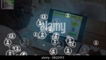 Image of falling icons over person using laptop Stock Photo