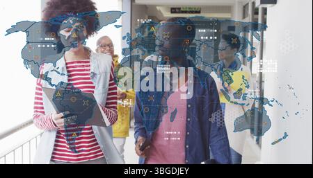 Image of world map over diverse business people in office Stock Photo