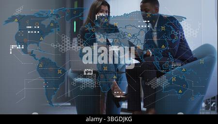 Image of world map over diverse business people in office Stock Photo