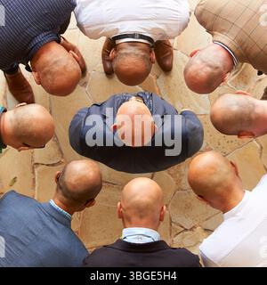 Group of bald men standing in circle overhead view Stock Photo