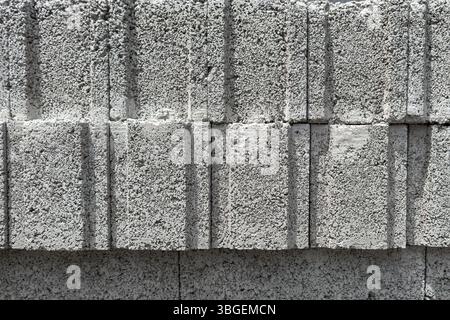 Close-up of stacked aerated concrete blocks with rough texture and vertical lines. Suitable for construction, texture backgrounds and industry use. Stock Photo