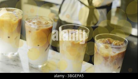 Image of falling yellow dots over ice coffee Stock Photo