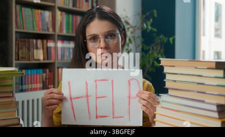 Sad worried tired exhausted girl Caucasian woman high school student teacher helpless stressful books studying learning college university library Stock Photo