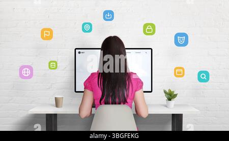 Woman working on desktop computer, VPN icons floating around her represent privacy, encryption, and secure connection. Stock Photo