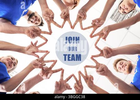Join Our Team. People showing V-sign and joining their fingers together indoors, bottom view. Employee search, recruitment concept Stock Photo