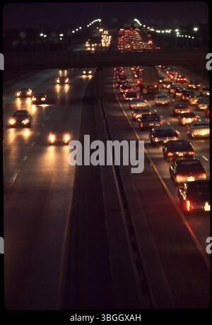 Traffic on an unidentified highway is shown during nighttime, with vehicle lights illuminating the road. The image captures movement and flow of vehicles after dark. Stock Photo