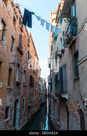 Laundry drying on a clothesline across a canal in Venice, Italy Stock Photo