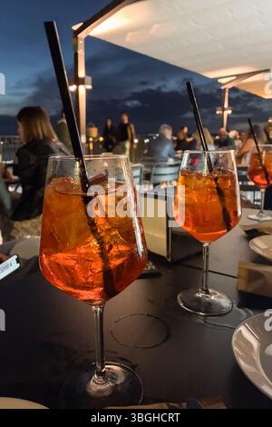 Aperol spritz cups in restaurant at night, Ortigia, Sicily Stock Photo