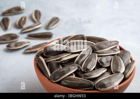 Black sunflower seeds in a bowl, on bright background,closeup Stock Photo