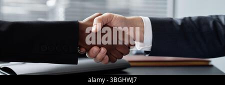 Website header shot of Caucasian man and Black woman shaking hands making agreement at office desk Stock Photo