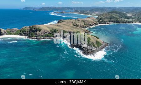 Aerial view of a rugged peninsula with rolling hills and turquoise waves crashing against rocky cliffs. Pristine beaches and dramatic coastline stretc Stock Photo