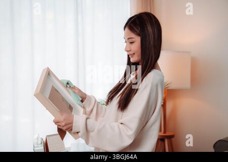 Asian Woman Cleaning Home Housekeeping Hygiene Homemaker House Happy Housework, Young Lady Joyfully Maintaining a Clean and Comfortable Living Room wi Stock Photo