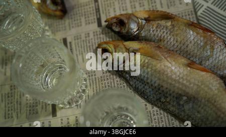 Vodka Glasses on Table with Dried Fish – Traditional Russian Snack Stock Photo