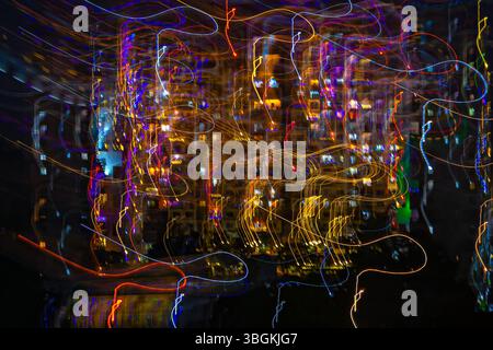 Intentional camera movement slow shutter speed image of illuminated, colorful festival lights at night. Stock Photo