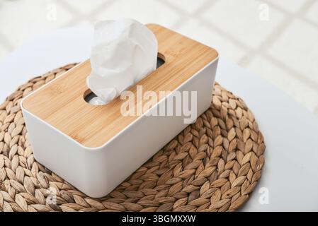 White tissue box with wooden bamboo top on table close up Stock Photo