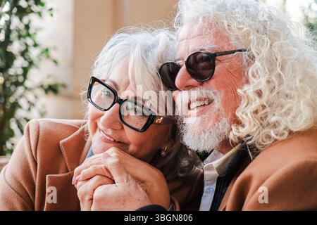 A loving elderly couple sharing a warm and affectionate moment while holding hands, radiating joy and connection, as they celebrate their romance Stock Photo