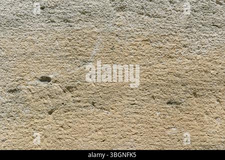 Close up of a rough stone wall displaying unique textures and colors Stock Photo