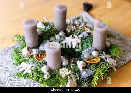 Advent wreath decorated with natural ornaments, wooden decorations and Christmas baubles made from mixed fir and conifer branches and gray candles Stock Photo