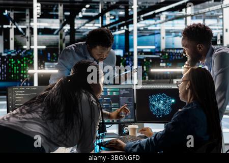 Data center engineering team implements AI virtualization frameworks to optimize server clusters. Teamworking server hub colleagues do artificial intelligence predictive analysis Stock Photo
