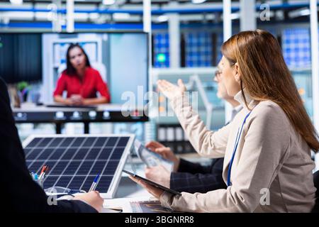 Investors evaluating photovoltaics factory production efficiency during online videocall before investing. Shareholders doing teleconference meeting with managers to ask technical questions Stock Photo
