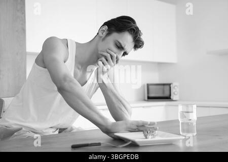 Young man with anorexia refusing from food in kitchen Stock Photo