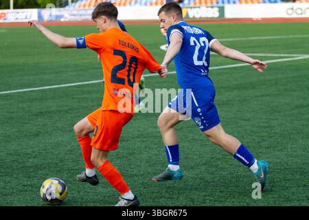 "Action from a Lithuanian II Lyga B Division football match – players in motion during a regional league game." Stock Photo
