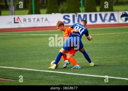 "Action from a Lithuanian II Lyga B Division football match – players in motion during a regional league game." Stock Photo