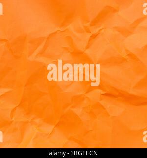 Top view and full frame of wrinkled or crumpled orange paper is used as crumpled orange paper background texture. Stock Photo