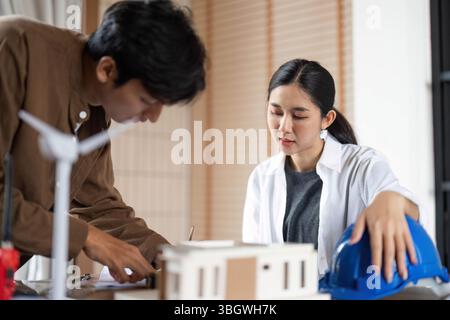 ESG Principles in Action. Young architects collaborating on sustainable building design. Stock Photo