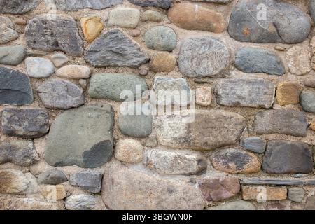Stone pebble house home wall background backdrop. Natural building materials concept. Stock Photo