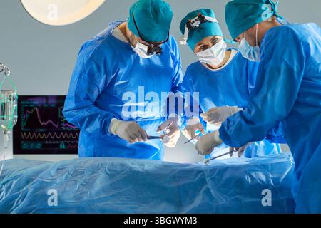 Professional doctors in blue medical uniform helping patient doing surgical operation at hospital. Stock Photo