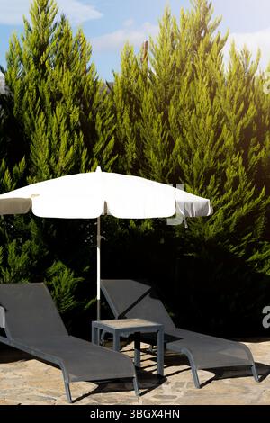 Two sun loungers in a stone house with a garden at sunset Stock Photo