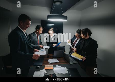 Business professionals gathered around a table for a focused meeting session Stock Photo