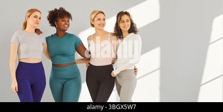 Isolated shot of four athletic mixed race women dressed in activewear Stock Photo