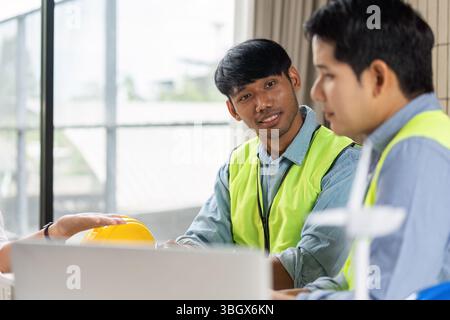 Green tech collaboration among engineers in sustainable planning meeting Stock Photo
