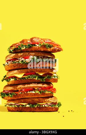 A Colorful Stack of Sandwiches Against a Bright Yellow Background Showcasing Their Appeal Stock Photo