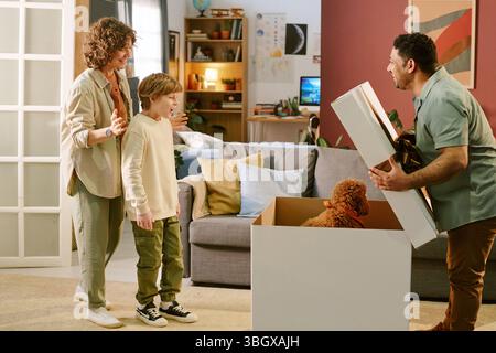 Caucasian Boy Receiving First Pet Puppy at Home with Parents Smiling Stock Photo