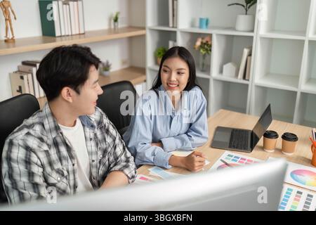 UX and UI Collaboration. Designers discussing project ideas in a modern workspace. Stock Photo