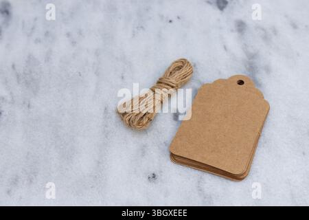 Blank Paper Gift Tags with Twine on Marble Surface with Blank Space for Text Stock Photo