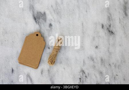 Stacked Kraft Gift Tags with Twine on Marble Background with Copy Space Stock Photo