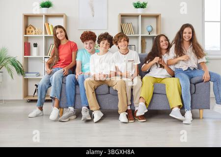 Group Portrait Of Happy Students Or Friends Sitting Together On A Couch Stock Photo