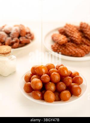 Luqaimat or awameh, Arabic Middle Eastern dessert, crispy, on white background. Stock Photo