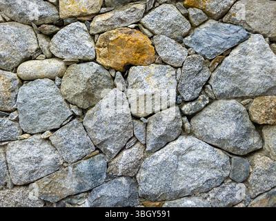 Old stone wall made of natural stones and fieldstones Stock Photo